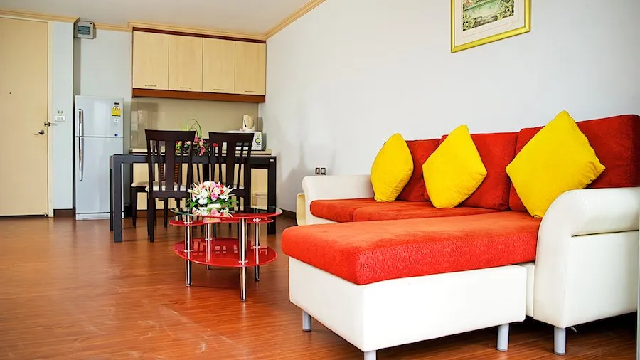 Junior Suite 70 sqm living area with the kitchen and dining table behind the sofa